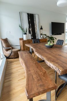 a wooden table with two benches in front of it and a flat screen tv on the wall