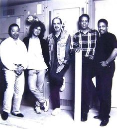 four men are standing in front of lockers