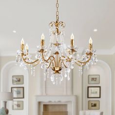 a chandelier hanging from the ceiling in a room with white walls and furniture