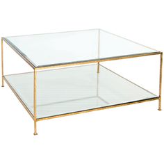 a glass and gold coffee table with two shelves on each side, one shelf is empty