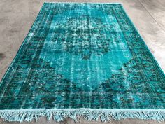 a large blue rug with fringes on the bottom and an area rug in the middle