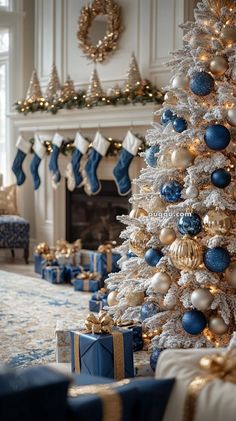 a white christmas tree with blue and gold ornaments in a living room decorated for christmas