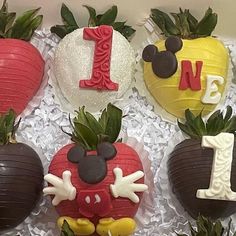 four decorated strawberries in the shape of mickey mouses and one strawberry for 1st birthday