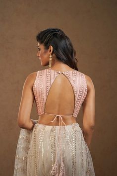 If you seek a divaesque charm at festive occasions, this embroidered peach blouse is a must-have. The inverted V-neck back and drawstrings add a dash of drama that will effortlessly complement your belt-accented ruffle saris. You can also channel Bollywood diva vibes pairing it with a gharara and dupatta for the Sangeet night. Product Features: Blouse Color: Peach Fabric: Brocade Neck: V-Neck Sleeves: Sleeveless Padded/Non Padded: Padded Occasion: Festivewear, Partywear Product Type: Blouse Disclaimer: There will be slight difference in digital to actual image Sangeet Night, Peach Fabric, Peach Blouse, Padded Blouse, Choli Designs, Sleeveless Skirt, Fancy Blouse, Backless Blouse