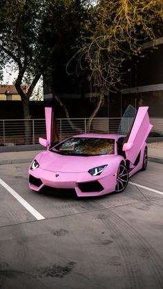 a pink sports car parked in a parking lot