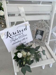 a white chair with a sign and flowers on it