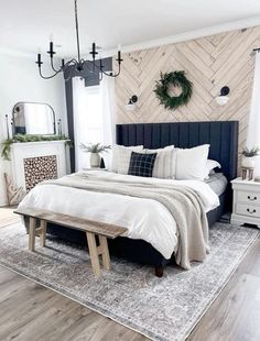 a bedroom with a bed, dresser and fireplace in the corner is decorated with greenery