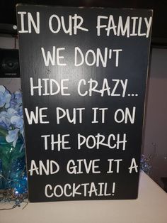 a sign that says in our family we don't hide crazy we put it on the porch and give it a cocktail