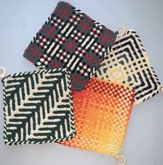 three woven bags with different patterns on them sitting next to each other, one is orange and the other is black