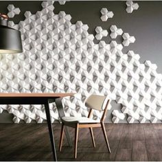 a dining room table with two chairs next to a wall that has geometric shapes on it