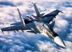 a fighter jet flying through the sky above clouds