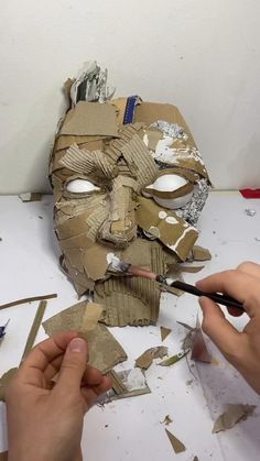 someone is making a mask out of cardboard