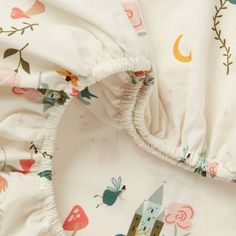 an unmade bed with a castle print on the cover and ruffles at the bottom