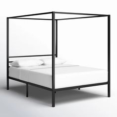 a black metal bed frame with white pillows on top and bottom, in front of a white background