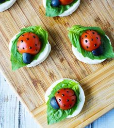 ladybug cupcakes with lettuce leaves and blueberries on them