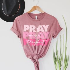 Searching for the perfect faith-based tee? Well, we present to you our Pray On It Tee. This vivid pink shirt with our catchy phrase is great when paired with skinny jeans and a scarf or going casual in sweatpants. With this t-shirt, wear your heart on your sleeve - literally! “If you remain in me and my words remain in you, ask for whatever you want and it will be done for you.” - John 15:7 God Shirts, John 15 7, Women Of The Bible, Pray On It, Bible Verse Wall Decor, Catchy Phrases