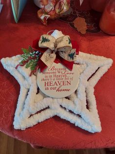 a star shaped ornament on top of a red table cloth with a ribbon