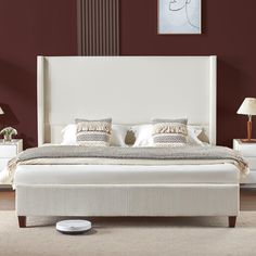 a white bed sitting in a bedroom on top of a hard wood floor next to a lamp