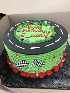 a birthday cake in the shape of a race track with green frosting on top