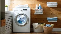 a washer sitting next to a dryer in a room filled with towels and other items