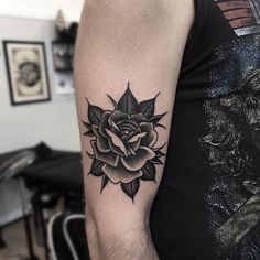 a black and white rose tattoo on the arm