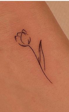 a small flower tattoo on the side of a woman's right arm and leg