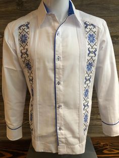 Mexican Guayabera.  Handcrafted in Merida, Yucatan Mexico. Made out of Cotton & Polyester Fabric Blend Royal Blue Cross Stitch Embroidery Two Embroidery Panels Long Sleeve.  Beautiful and Elegant Guayabera Shirt.  Traditional Mexican Shirt  Good for Casual wear, Wedding, Fiesta, Tropical, Birthday or any other occasion. 100% Brand New  New Inventory  Please refer to size chart for proper fitment.  We gladly accept returns with these terms and conditions.  We do charge a 25% Fee on any returns. This helps compensate for shipping fees, packing supplies and labor costs.  Exchanges have no cost.  Customer is responsible for shipping items back.  We do not provide prepaid labels.  Items should be returned just as received and with no damages or signs of wear. No returns on Clearance Items.  Tha Elegant Fitted Shirt With Resham Embroidery, Traditional Embroidered Shirt For Formal Occasions, Traditional Long Sleeve Wedding Shirt, White Long Sleeve Shirt With Machine Embroidery, Traditional Long Sleeve Shirt With Patterns, Formal Festive Embroidered Shirt, Festive Formal Embroidered Shirt, Traditional Long Sleeve Shirt, Festive Embroidered Fitted Shirt