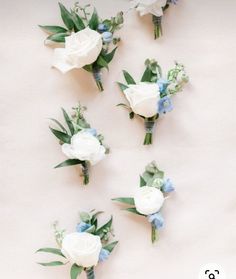 white and blue flowers are arranged on a table