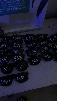 many glasses with words written on them sitting next to each other