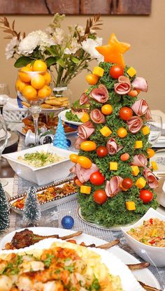 a christmas tree made out of fruits and vegetables on a table with other food items