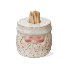 a ceramic toothbrush holder with a santa claus face on it's head and wooden sticks sticking out of the top