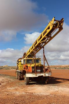 a large yellow crane sitting on top of a dirt field