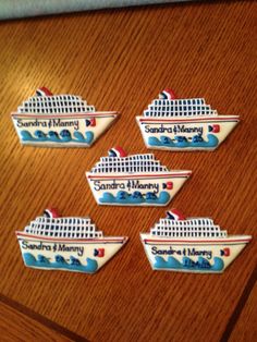 four magnets depicting the same ship as they are on top of a wooden table