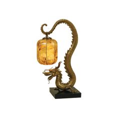 a golden dragon lamp sitting on top of a black base