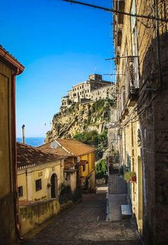 an alley way with buildings on the hill in the background