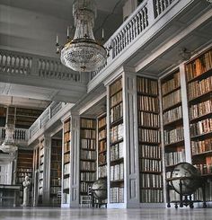 an old library with chandelier and bookshelves filled with lots of books