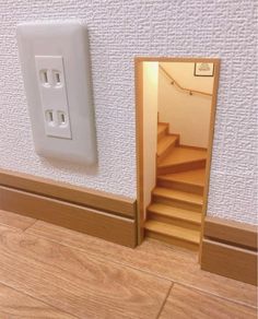 an open door to a room with stairs and a light switch