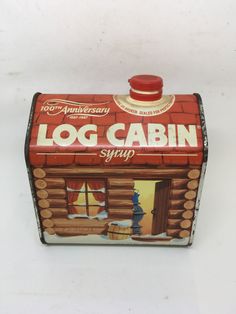 an old fashioned log cabin syrup canister