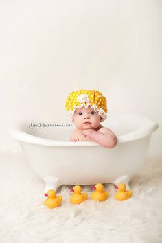 a baby in a bathtub with rubber ducks