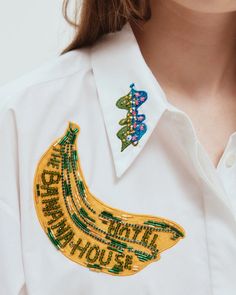 a woman wearing a white shirt with a banana embroidered on it