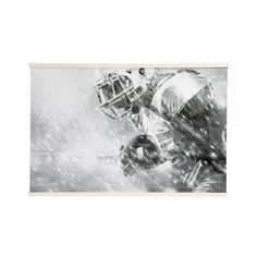 a black and white photo of a football player in the snow with his helmet on