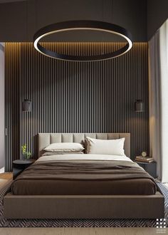 a large bed sitting in the middle of a bedroom next to a wall mounted light