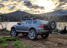 an suv parked on the side of a lake