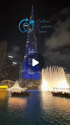 the burj tower is lit up at night with water fountains in front of it