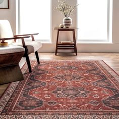 a large red rug with an ornate design on the floor in front of a window