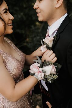 a man in a tuxedo and a woman in a sequin dress smile at each other