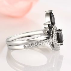 two wedding rings with black and white diamonds