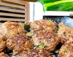 some meat patties are cooking in a skillet