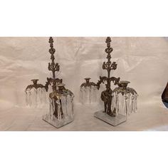 two crystal candlesticks are sitting on top of each other, one has a candle holder in the shape of an elephant