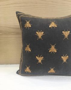 a black pillow with gold bees on it